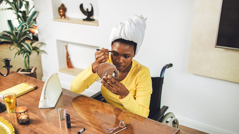 Woman applying makeup to face