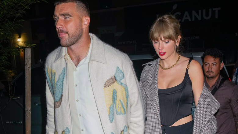 Travis Kelce and Taylor Swift walking hand in hand 