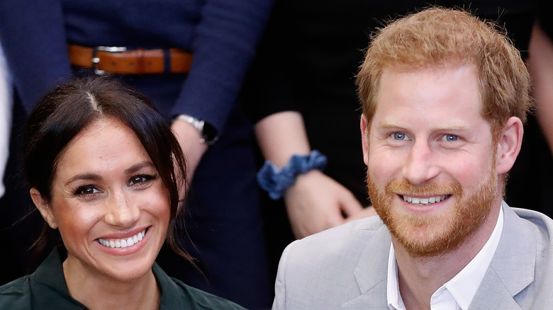 Meghan and Harry smile at an events