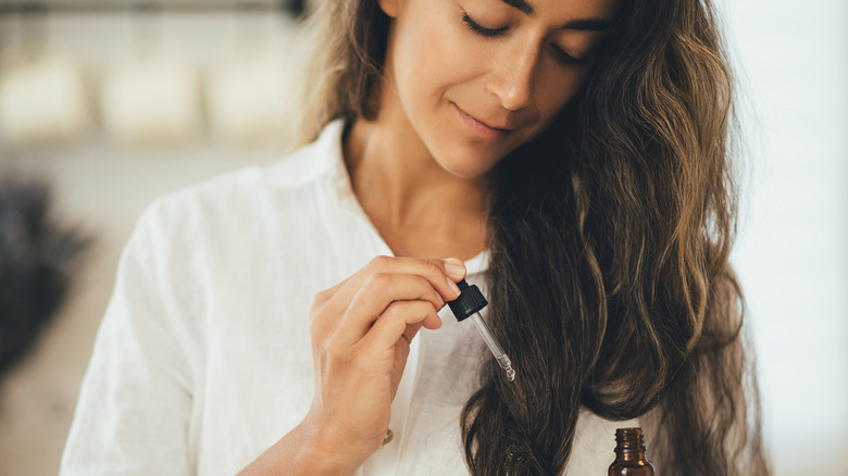 Woman applying oil to hair