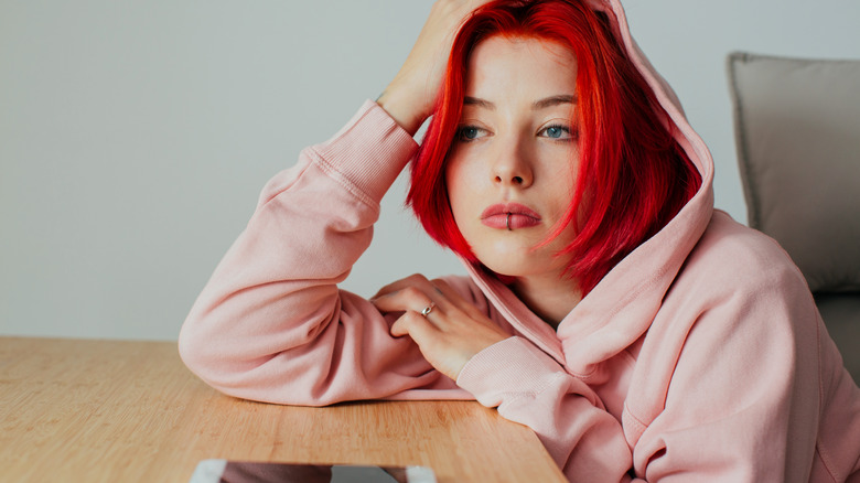 Sad teen girl red hair pink hoodie