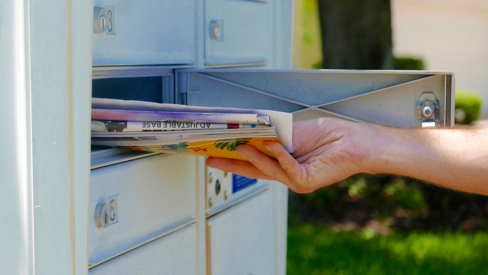 Person retrieving mail from mailbox