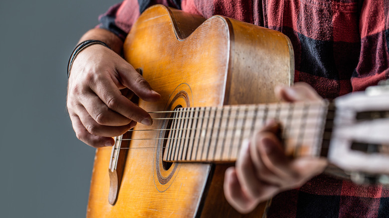 Person playing acoustic guitar