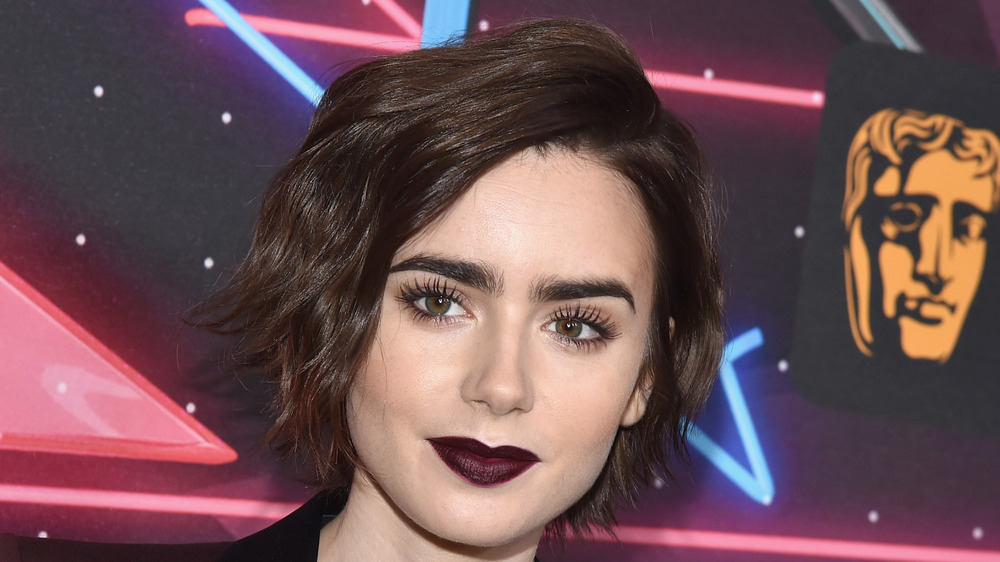 Lily Collins smiles on the red carpet