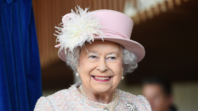 Queen Elizabeth smiling in pink hat