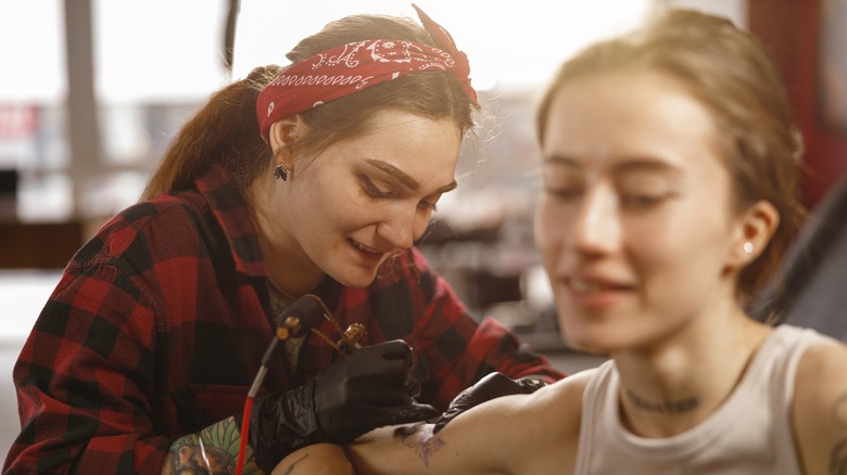 woman getting a tattoo on her arm