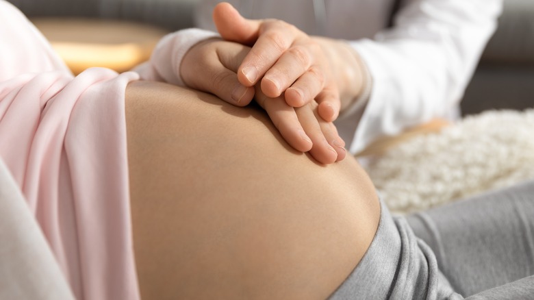 pregnant woman touching stomach