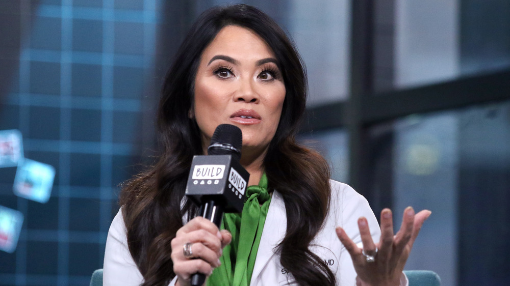 Dr. Pimple Popper speaks onstage at an event