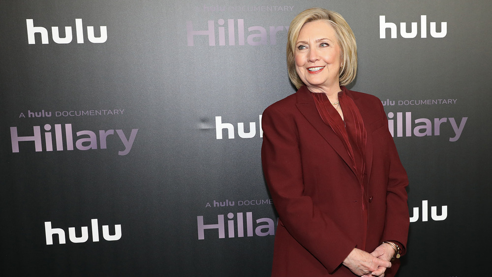 Hillary Clinton smiling in red pantsuit