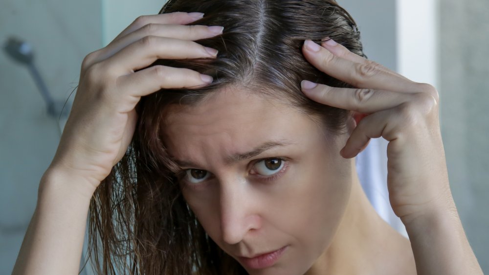 Woman inspecting hair roots 