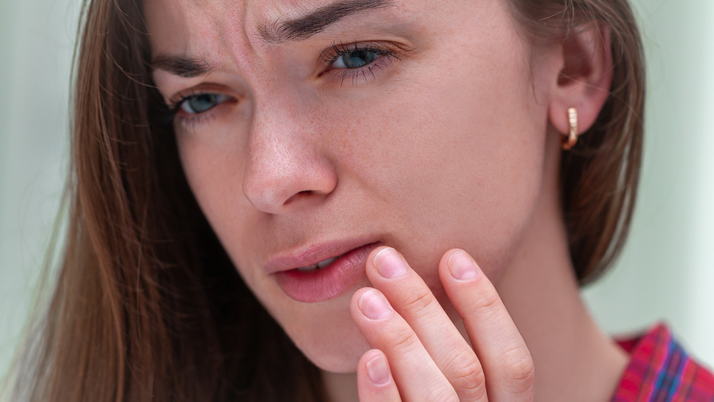 Woman touching corner cold sore