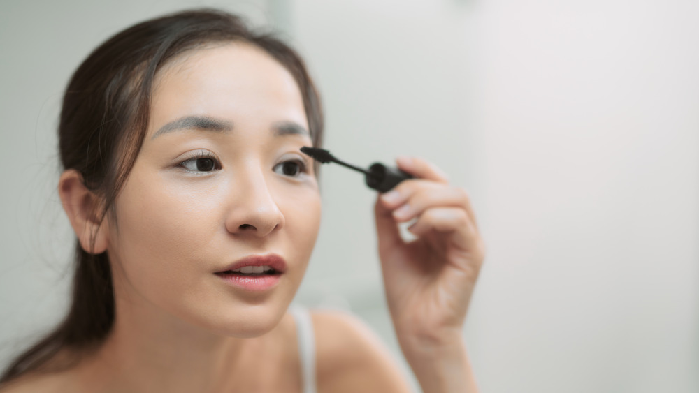 Woman applying mascara 