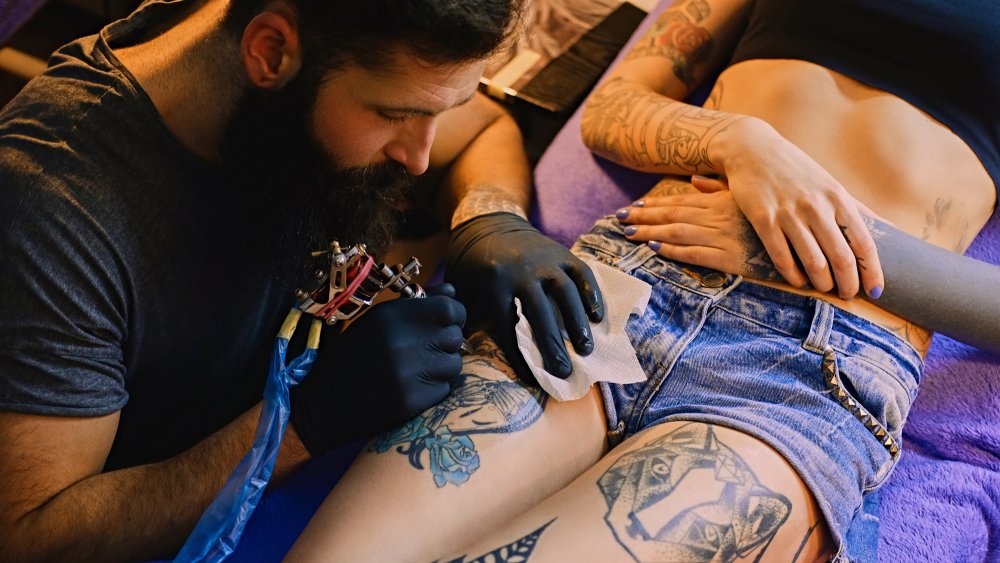 Tattooist making by professional artist is tattooing body woman using  machine in a creative design work studio Stock Photo  Alamy