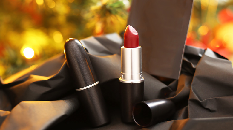 A Mac Cosmetics red lipstick in front of a Christmas tree