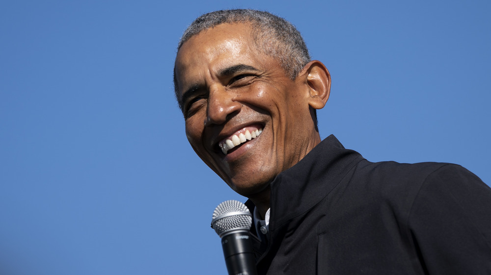 Barack Obama smiling with a microphone