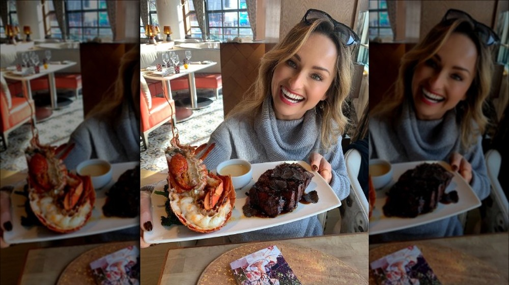 Giada De Laurentiis holding a plate of lobster and steak