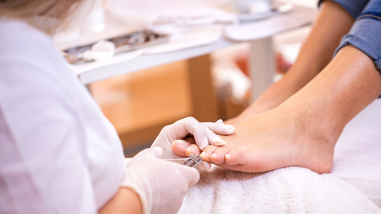 Doctor cutting a woman's toenails