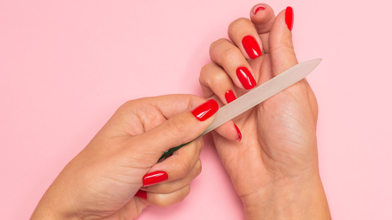 Woman filing red nails