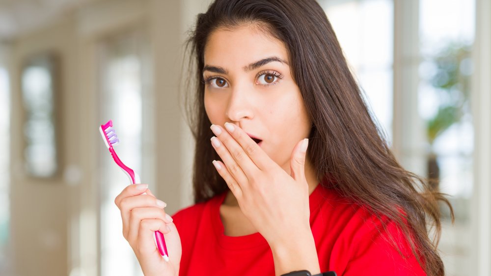 woman holding toothbrush