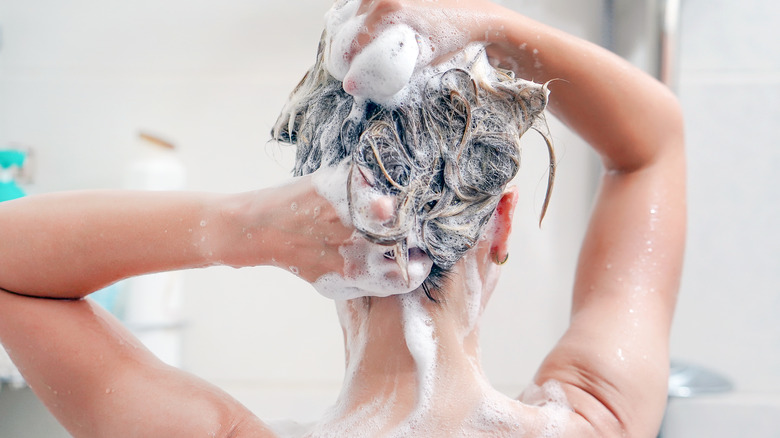 A woman co-washing her hair in the shower