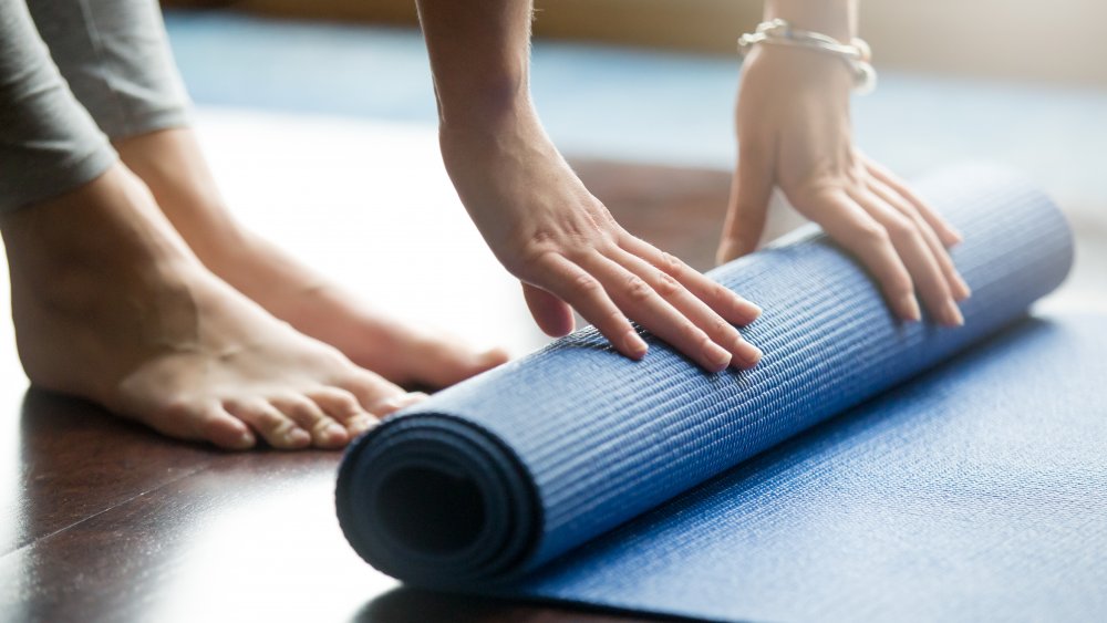 woman unrolling yoga mat