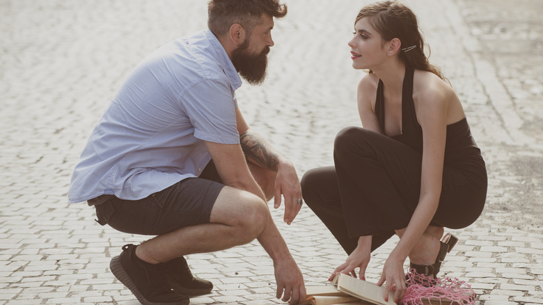 Man helping woman pick up dropped items