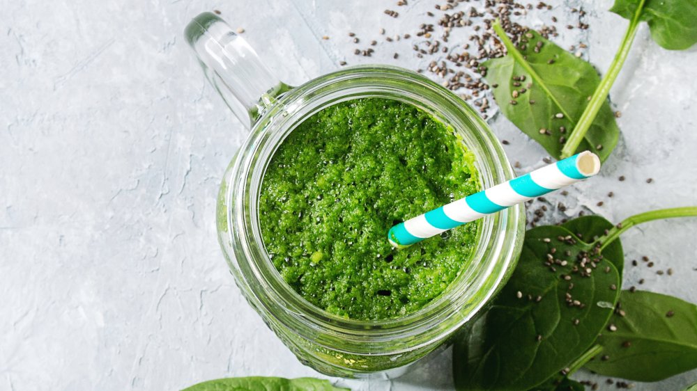 Woman pouring green smoothie