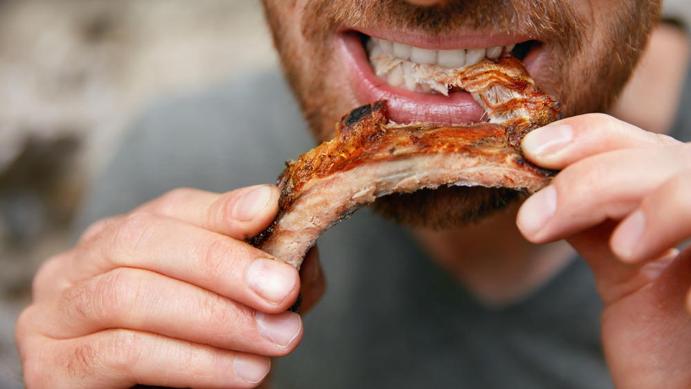 A man eating BBQ ribs