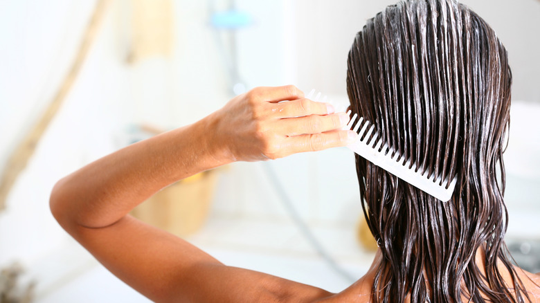 Woman applying conditioner to her hair