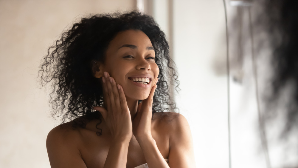 Woman smiling with hands on her face