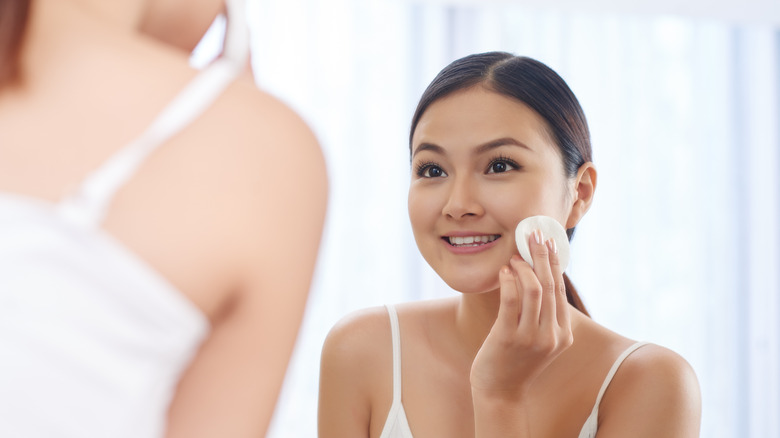 Woman applying witch hazel toner