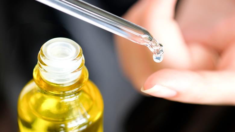 Woman holding a drop of an essential oil