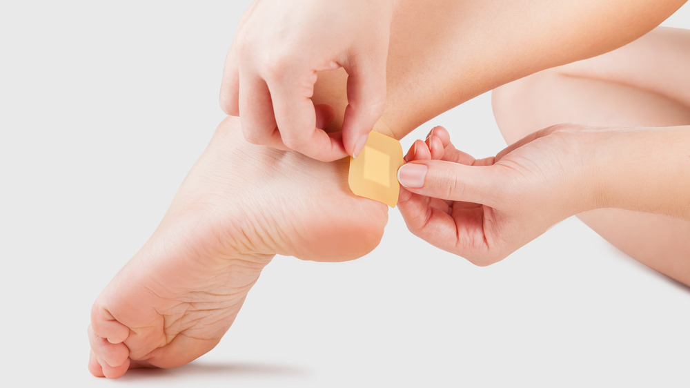 Woman putting bandage on foot