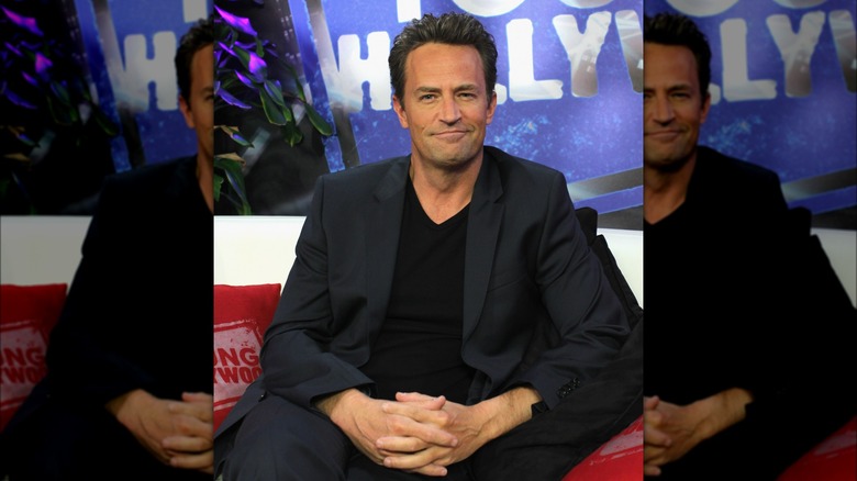 Matthew Perry sitting and smiling