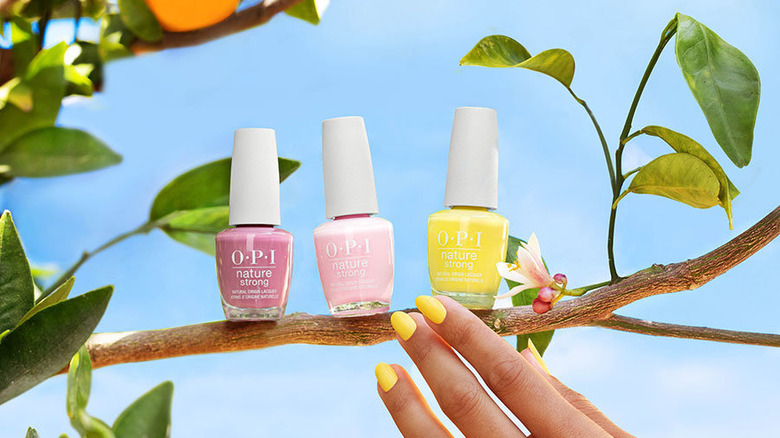 Three bottles of OPI Nature Strong on a branch 