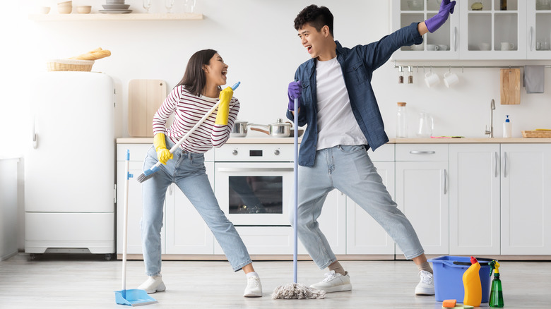 couple dancing and cleaning kitchen