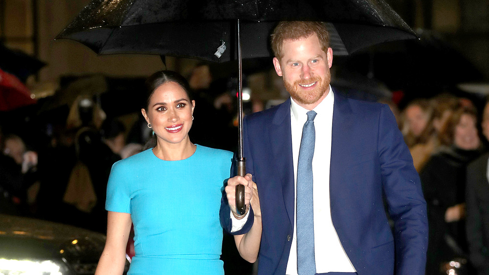 Prince Harry and Meghan Markle walking in the rain