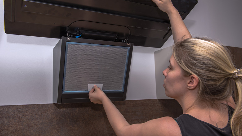 Woman working with range-hood filter