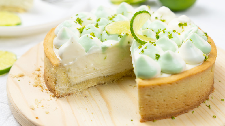 A key lime pie with a slice cut out