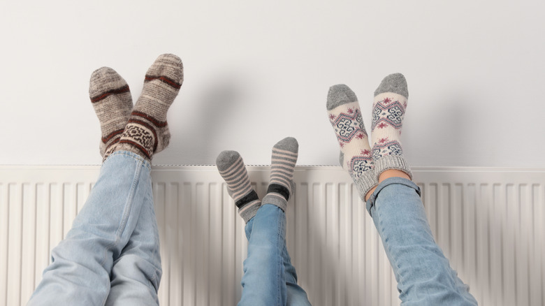 Family warming feet on radiator