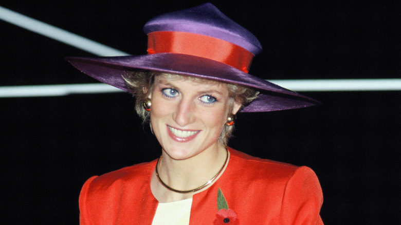 Princess Diana wearing a red and purple hat while smiling