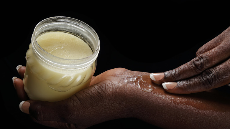 Black woman applying shea butter