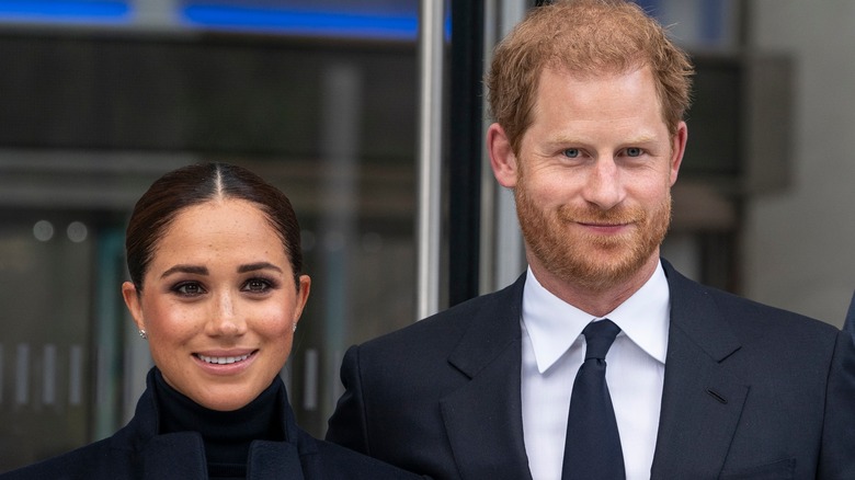 Prince Harry and Meghan Markle smiling at an event in New York