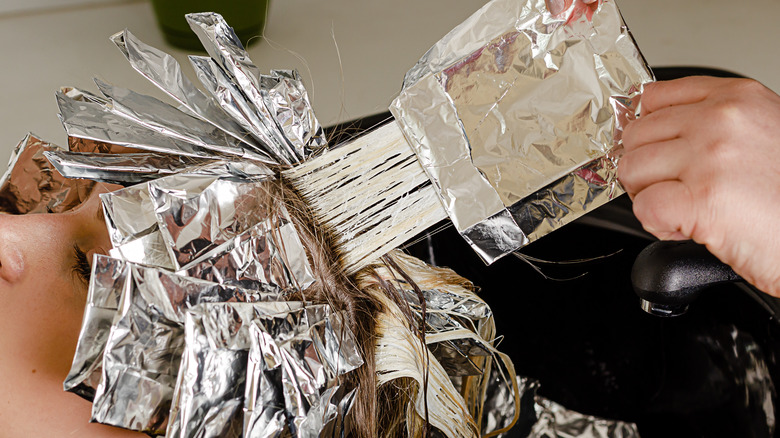 Stylist taking foils out of someone's hair