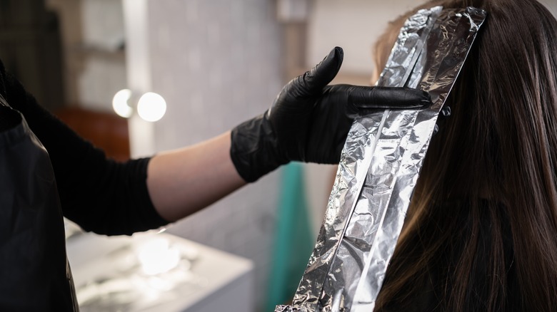 Woman getting foil highlights put in