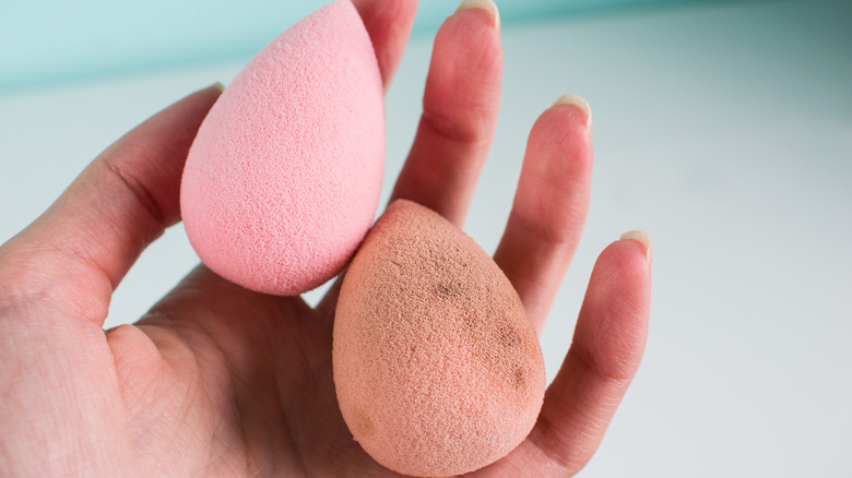 Hand holds a stained Beautyblender