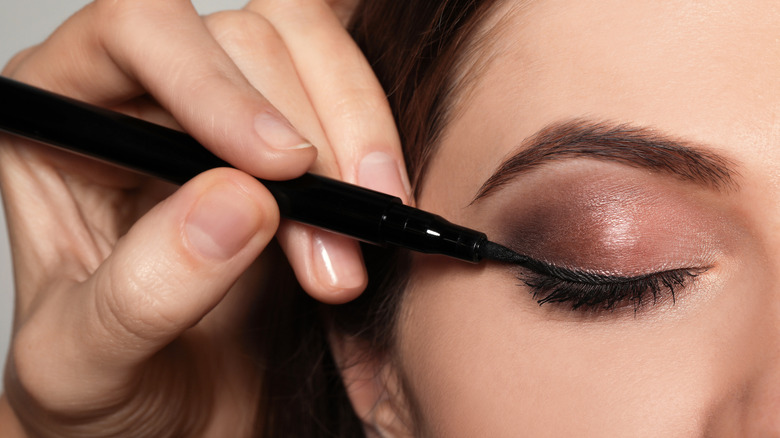 Woman applying liquid eyeliner