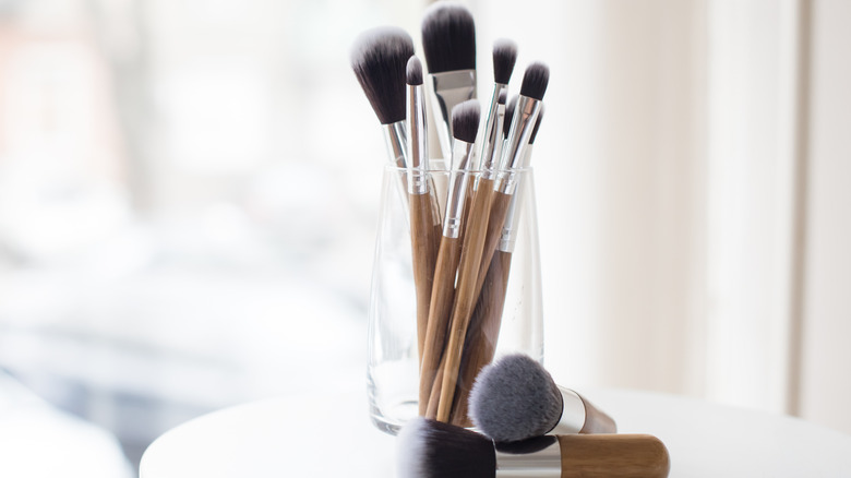 Professional makeup brushes in a glass