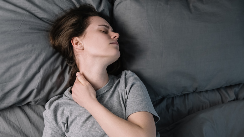 Woman having neck pain during sleep