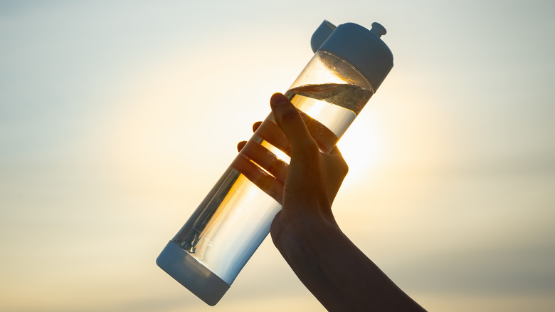 hand holding plastic reusable bottle